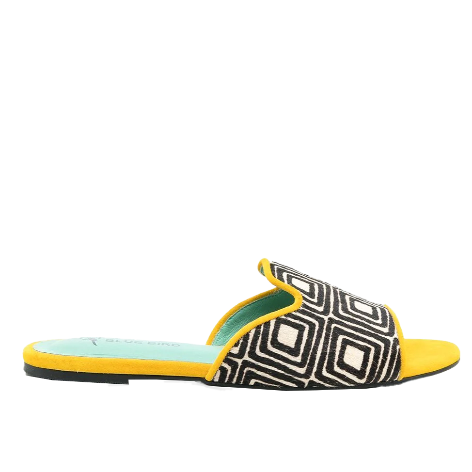 a woman's yellow and black slip on sandals